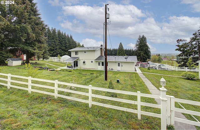 view of yard featuring a rural view, an outdoor structure, and fence private yard