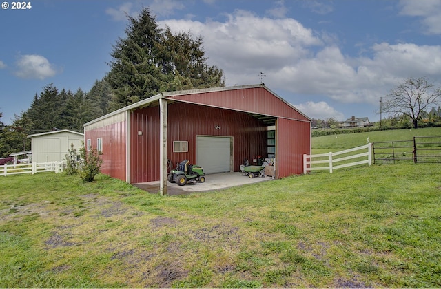 view of pole building with fence and a lawn