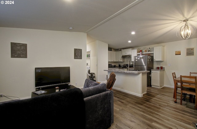 living room with dark wood-style floors, a notable chandelier, recessed lighting, vaulted ceiling, and baseboards