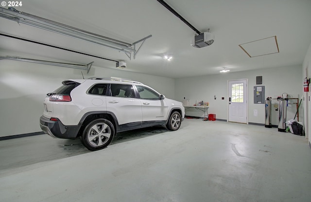 garage featuring a garage door opener, electric panel, and baseboards