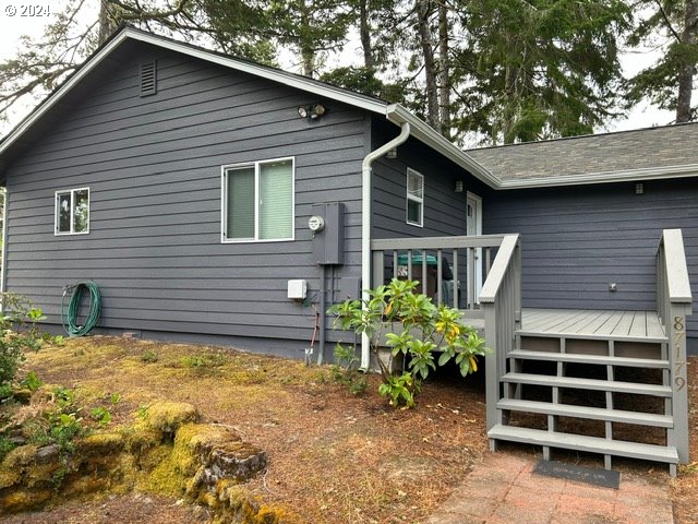 rear view of house featuring a wooden deck