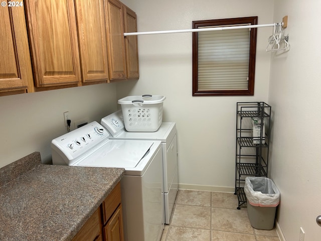 laundry room featuring light tile patterned floors, separate washer and dryer, and cabinets