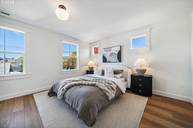 bedroom with dark hardwood / wood-style flooring