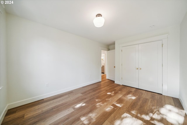 unfurnished bedroom with light hardwood / wood-style floors and a closet