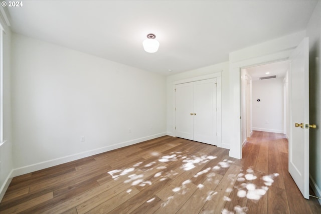 unfurnished bedroom with wood-type flooring and a closet