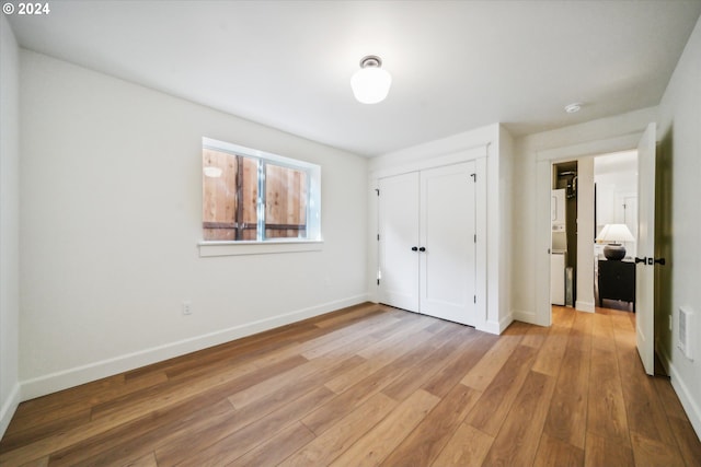 unfurnished bedroom featuring light hardwood / wood-style flooring and a closet