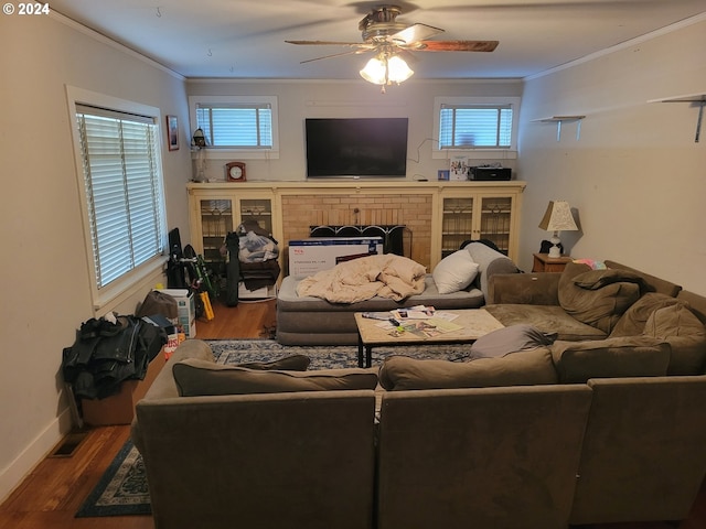 living room featuring crown molding, ceiling fan, a fireplace, and hardwood / wood-style flooring