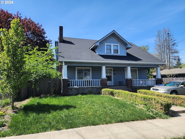 view of front facade featuring covered porch and a front lawn