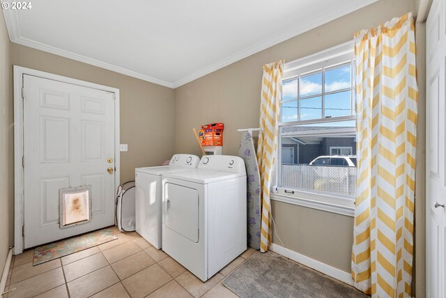 laundry area with washer and dryer, ornamental molding, and light tile patterned floors