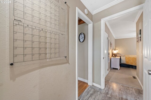 corridor with crown molding and light wood-type flooring