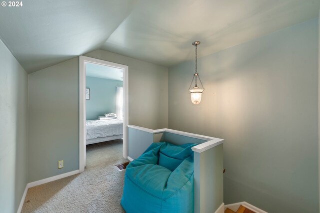 living area with carpet and vaulted ceiling