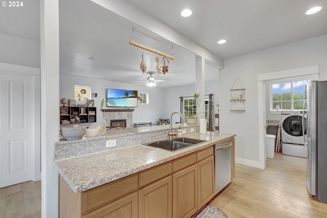 kitchen featuring light brown cabinets, sink, light wood-type flooring, and stainless steel appliances