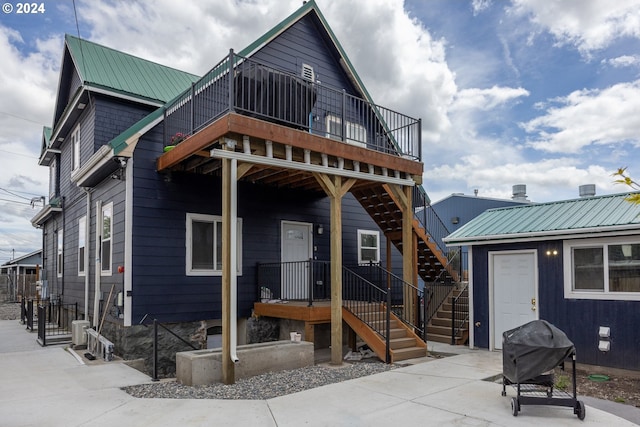 rear view of property with metal roof, stairway, a patio, and central air condition unit