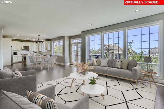 living room with light hardwood / wood-style floors and an inviting chandelier