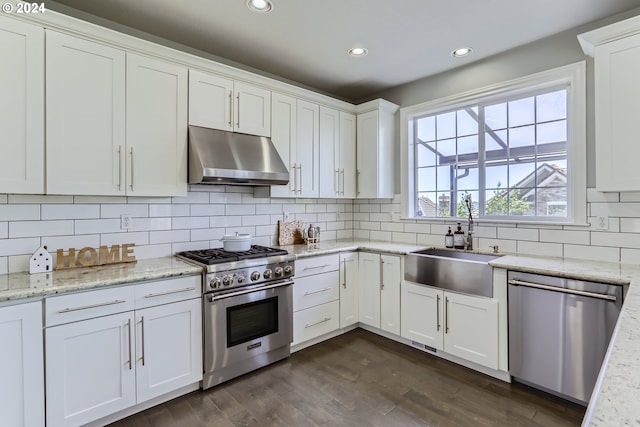 kitchen featuring sink, stainless steel appliances, tasteful backsplash, light stone counters, and white cabinets