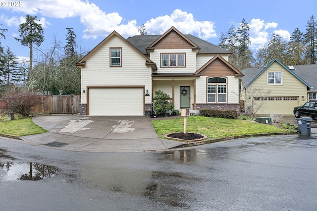 craftsman-style house featuring an attached garage, brick siding, fence, driveway, and a front lawn