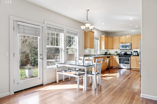 kitchen featuring stainless steel appliances, recessed lighting, light wood-style flooring, an inviting chandelier, and light brown cabinetry