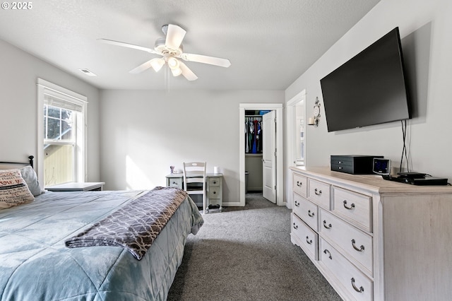 carpeted bedroom featuring a closet, visible vents, a spacious closet, ceiling fan, and a textured ceiling