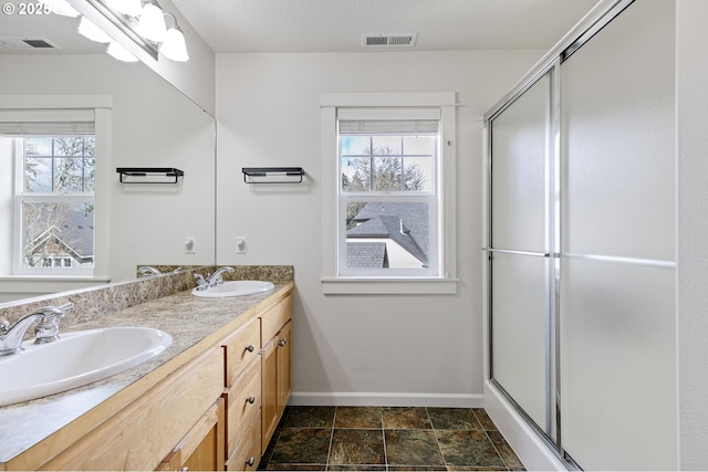 bathroom with a healthy amount of sunlight, visible vents, and a sink