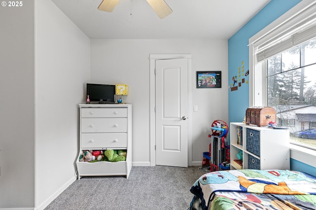 carpeted bedroom featuring baseboards and a ceiling fan