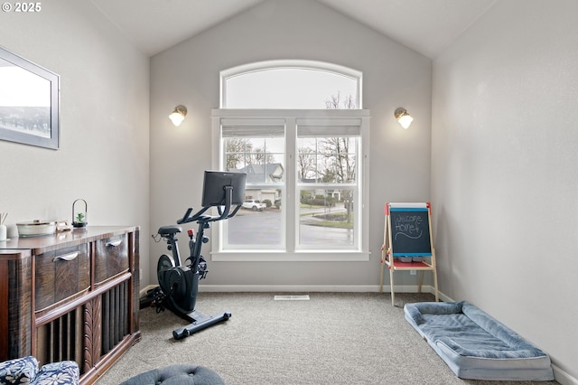 exercise room with carpet floors, lofted ceiling, visible vents, and baseboards