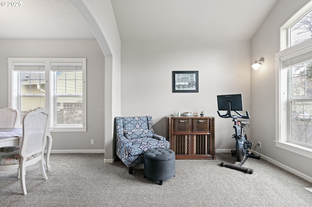 interior space featuring arched walkways, carpet floors, and baseboards