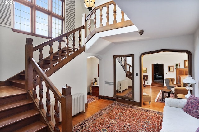 stairs featuring hardwood / wood-style flooring and radiator