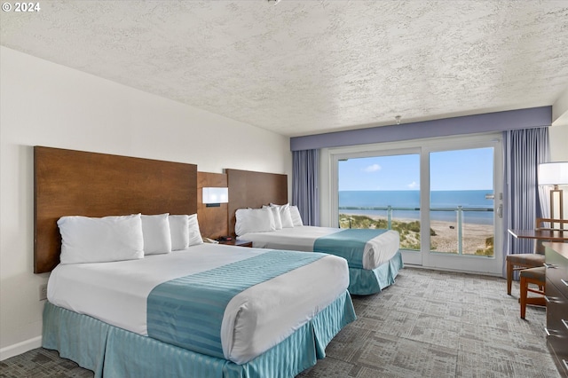 bedroom with a water view and a textured ceiling