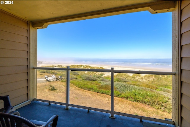 balcony featuring a beach view and a water view