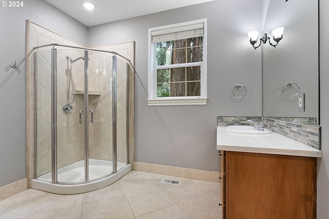 bathroom featuring a shower with shower door, vanity, tile patterned floors, and backsplash