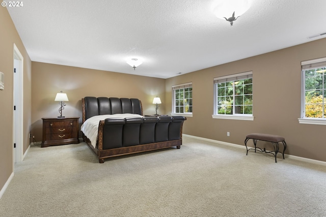 bedroom featuring a textured ceiling and light colored carpet