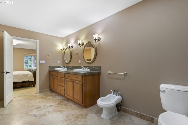 bathroom featuring toilet, vanity, and a bidet