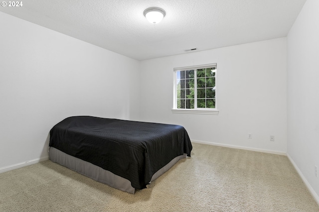 carpeted bedroom featuring a textured ceiling