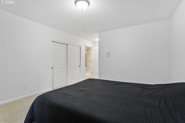 bedroom featuring carpet flooring, a textured ceiling, and a closet