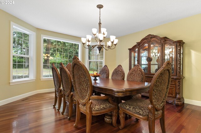 dining area featuring plenty of natural light, a notable chandelier, and dark hardwood / wood-style floors