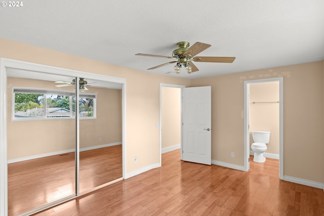 unfurnished bedroom featuring ensuite bathroom, ceiling fan, a closet, and light hardwood / wood-style floors