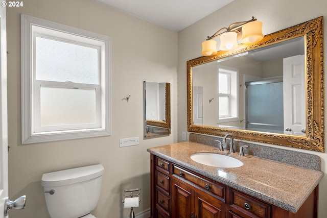 bathroom featuring vanity, toilet, and an enclosed shower