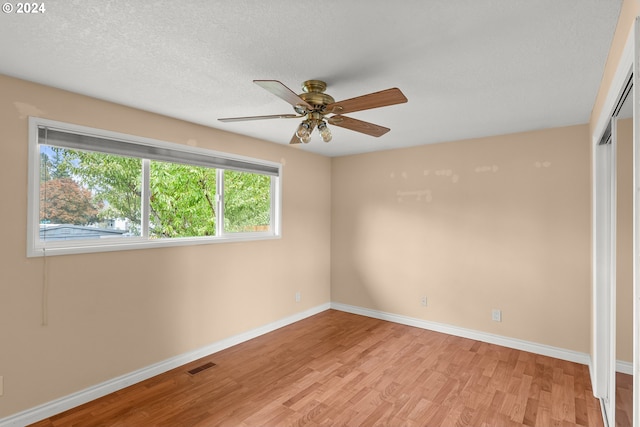 spare room with ceiling fan, light wood-type flooring, and a wealth of natural light