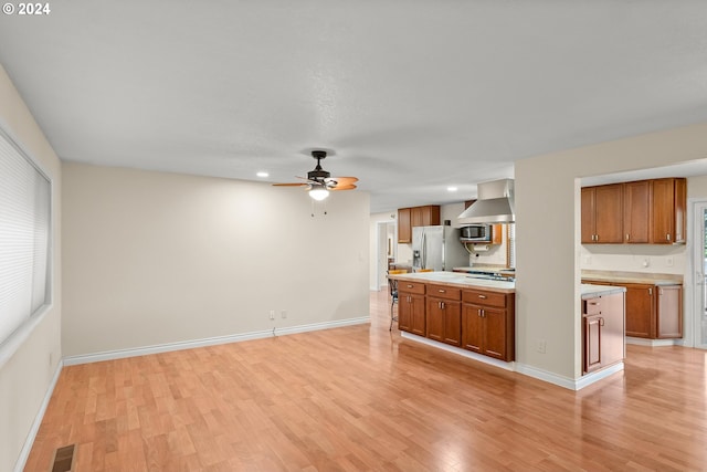 unfurnished living room featuring ceiling fan and light hardwood / wood-style floors