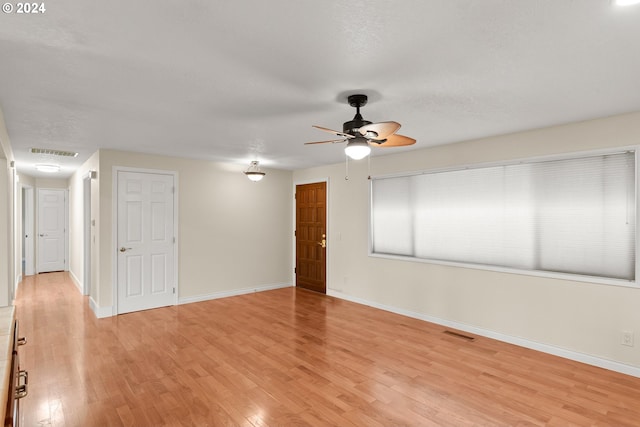 empty room featuring ceiling fan, light hardwood / wood-style floors, and a textured ceiling