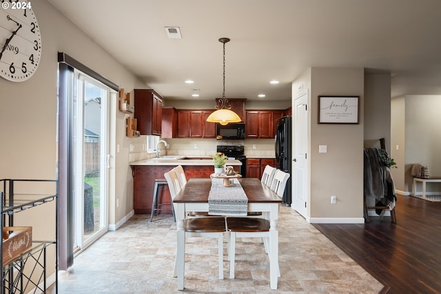 dining area featuring light hardwood / wood-style flooring, a wealth of natural light, and sink