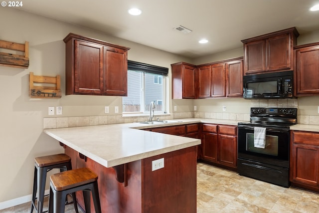 kitchen with a kitchen bar, kitchen peninsula, sink, and black appliances