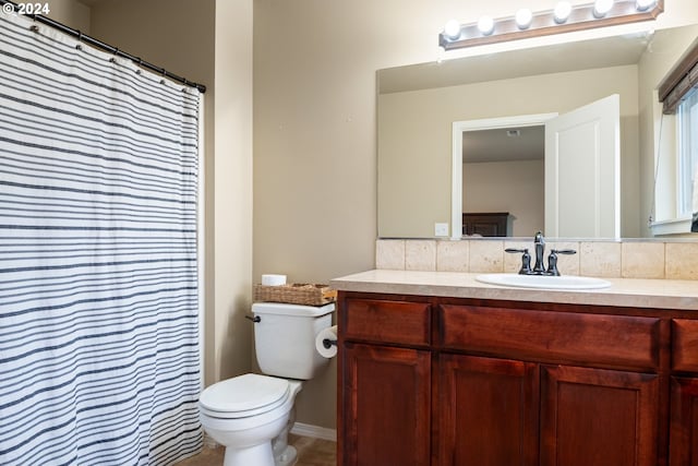 bathroom with backsplash, vanity, and toilet