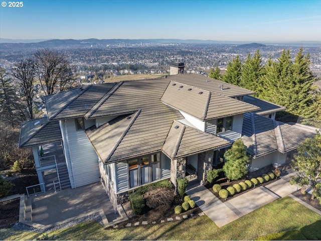 view of front of house with a chimney, a tile roof, and a mountain view