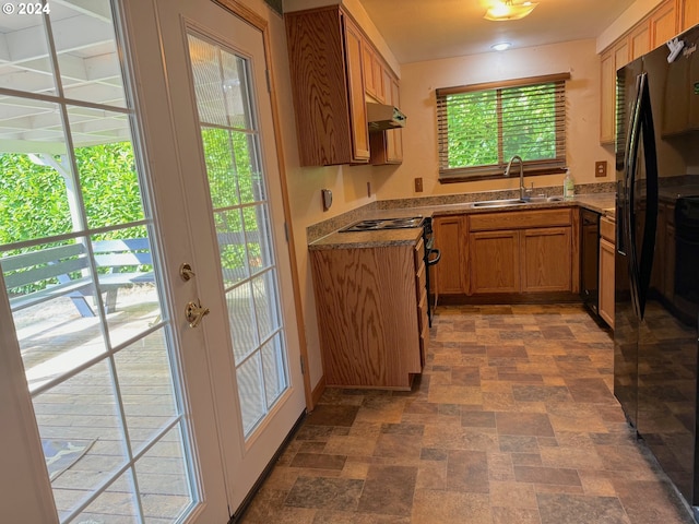 kitchen with black refrigerator with ice dispenser, stove, sink, and french doors