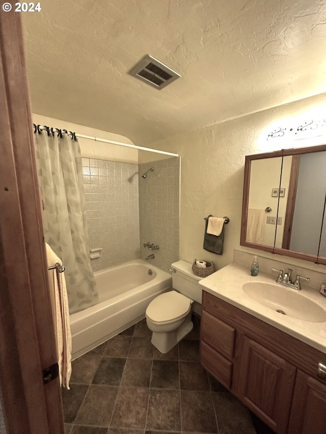 full bathroom featuring shower / tub combo with curtain, vanity, toilet, and a textured ceiling