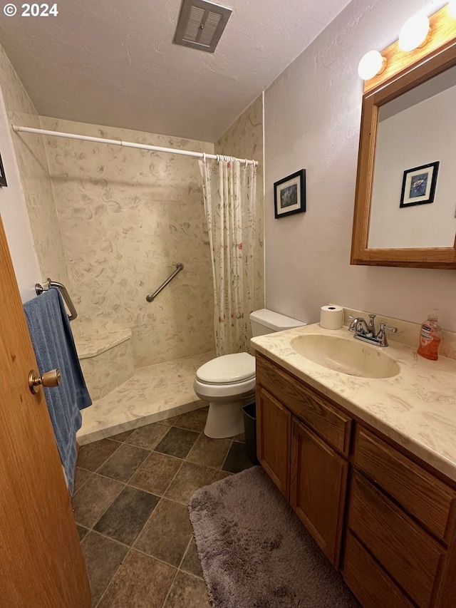 bathroom featuring curtained shower, tile patterned flooring, vanity, and toilet