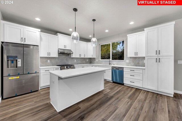 kitchen featuring white cabinets, stainless steel appliances, decorative light fixtures, and dark hardwood / wood-style floors