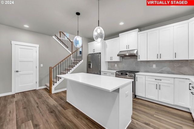 kitchen with pendant lighting, appliances with stainless steel finishes, hardwood / wood-style flooring, and white cabinets