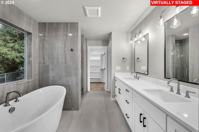 bathroom featuring vanity, shower with separate bathtub, and tile walls